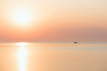 the boat sails on the sea at dawn