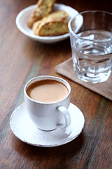 Cup of coffee with cantuccini  (Italian cookies) on rustic wooden background. 