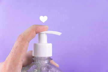 Man hand in container with alcohol gel on the light blue background
