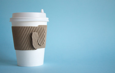 A disposable coffee Cup and a white container with food close-up on a blue background and space for copying. The concept of food delivery takeaway