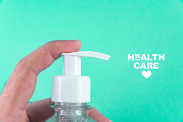 Man hand in container with alcohol gel on the light blue background