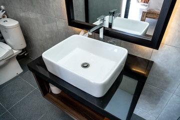 The photo of a white clean sink with the crane