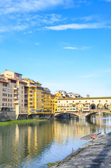 Famous Ponte Vecchio Bridge, medieval stone bridge over the Arno River in Florence, Tuscany, Italy. Major landmark of the Italian city. Amazing cityscape. Historical center, old town. Vertical photo.