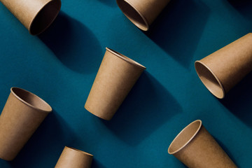 Eco friendly craft paper cups on green background.