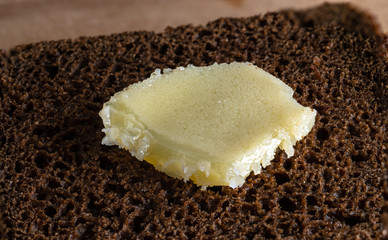 Ghee on a piece of coarse rye bread. Selective focus.