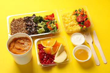Food delivery. Food in takeaway boxes on yellow background