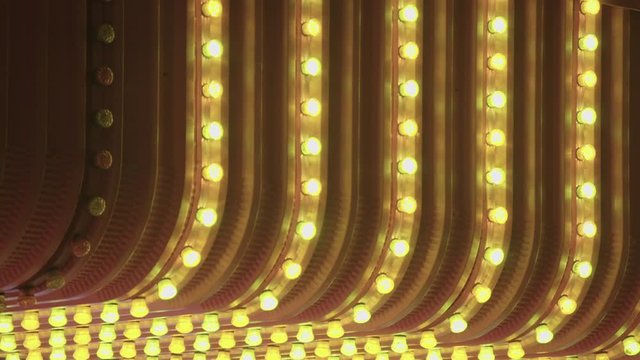 Flashing yellow light bulbs on a neon sign in a funfair or casino
