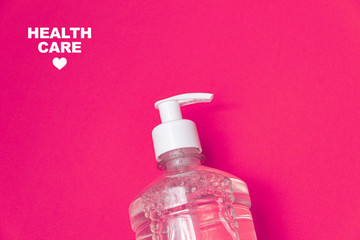 Container with alcohol gel on the orange background