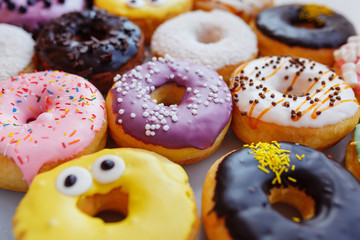 A lot of multi-colored donuts with different fillings, top view