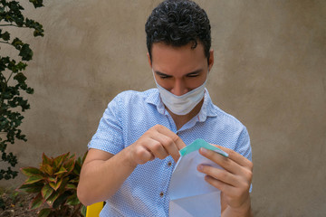 Young man making a homemade breathing mask, protection against the crown virus. Home sewing virus...