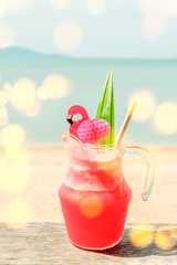 Colorful watermelon mocktail at the beach bar with sea background. Vacation, get away, summer outing concept. Bokeh effects