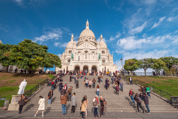 the white basilique of the sacré coeur, standing up the hill of Montmartre, Paris, with people at the front