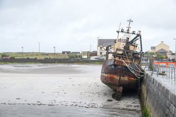 An old Fishing boat grounded in the harbor at Aran Islands, Ireland