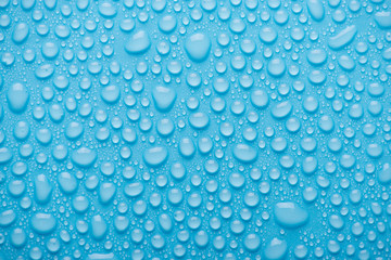 Top above overhead view close up photo of bright water drops on the blue background