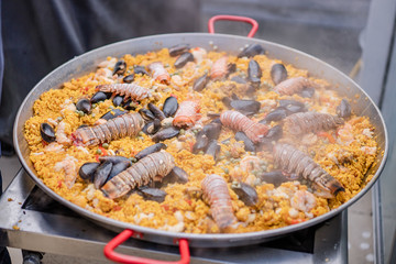 Paella de mariscos, plato con camarones, langosta, langostinos, almejas, arroz y verduras 