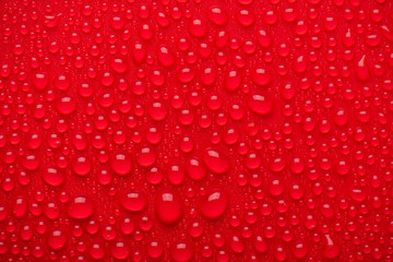 Close up cropped view photo image of shiny burgundy maroon bright color waterdrops on red background