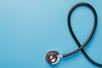 Fototapeta na wymiar November month charity mental problem research insurance concept. Flat lay top above overhead close up view photo of black stethoscope isolated on blue background with empty space