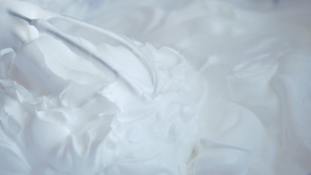 Confectionery workshop. Whipped protein cream with a whisk. Close-up. White fluffy cloud of cream. Decoration for the cake