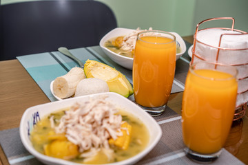 Ajiaco Santafereño, plato tipico colombiano, comida típica del interior de Colombia acompañado de jugo de mango 
