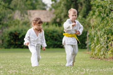 Young karate girl and boy train on the grass in backyard of home © marritch