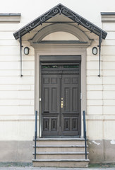 Old closed wooden doors, decorative outdoor entrance, front view building facade