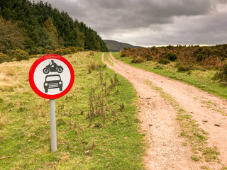 Signpost showing motorcycles and cars are not allowed to drive down the track over the countryside in the Brecon Beacons National Park.