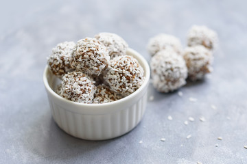 Healthy raw energy balls with cocoa, coconut, sesame, chia on white background. Healthy homemade paleo chocolate energy balls with rolled oats, nuts, dates. Raw vegan healthy dessert, selective focus