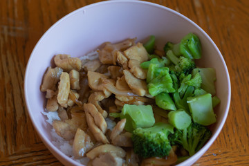 Cooked teriyaki chicken, steamed rice and broccoli in a pink bowl.