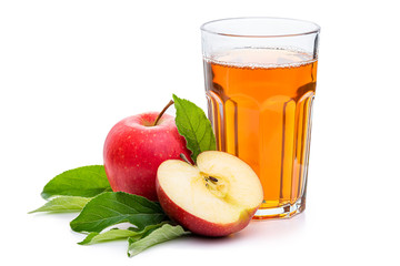 Apple juice in a glass surrounded by red apples and green leaves. Isolate on a white background.