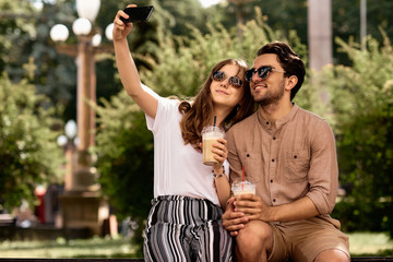 A young beautiful couple making selfies in the street