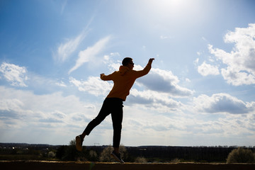 guy tourist freelancer on a background of blue sky with white clouds, bright sunny day, nature and human freedom