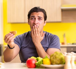 Man having hard choice between healthy and unhealthy food