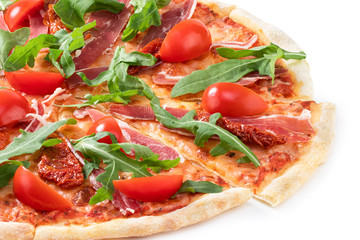 Pizza with Italian prosciutto, sun dried tomatoes and fresh arugula isolated on white background