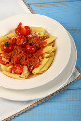 tomato sauce on penne pasta and small tomatoes