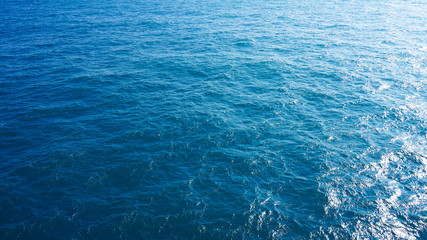 Pure turquoise blue water of the Pacific Ocean. reflection of the sun in the waves on the surface. Natural sea composition, texture, background. aerial view