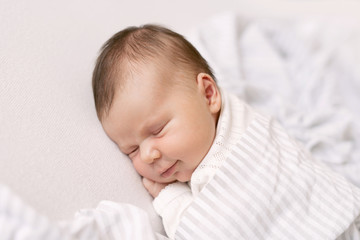 newborn baby sleeps and smiles