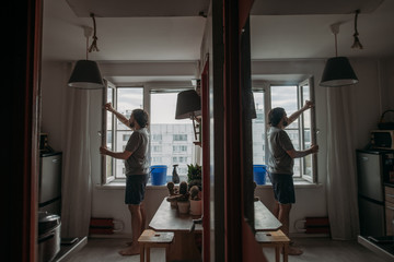 Naklejka na ściany i meble A man washes windows at home