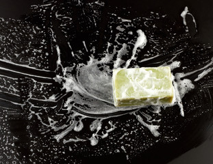 white soap foam and green soap on a black background, top view