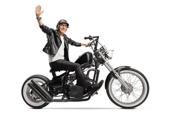 Elderly biker in leather jacket riding a chopper and waving