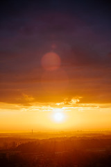 A beautiful warm sunrise outside the city. Fog hovering over the trees