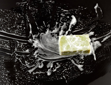 White Soap Foam And Green Soap On A Black Background, Top View