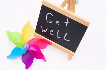 Get well writing on a slate. Plastic colorful toys, slate and protective. Get well concept. Positive background. Recovery concept. Healing concept. 