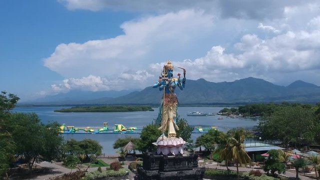 take off on a drone in front of the Shiva Taman Siwa monument in sunny weather against the backdrop of mountains and water Gilimanuk Melaya west bali indonesia