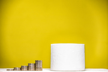 Toilettenpapier mit Geld auf gelbem Hintergrund.
