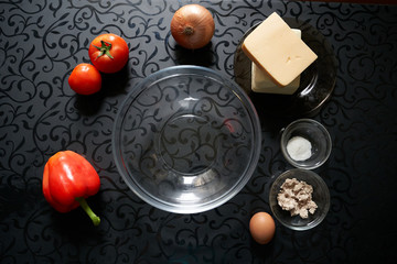 pizza products on black table background cheese butter sausage yeast tomato pepper