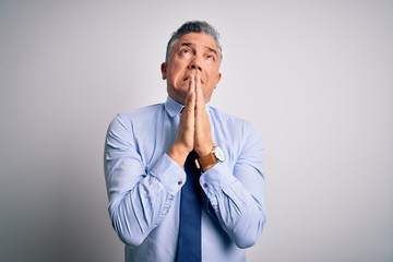 Middle age handsome grey-haired business man wearing elegant shirt and tie begging and praying with...