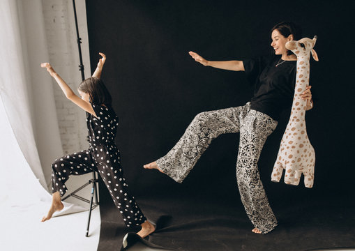 Vivacious And Happy Mother And Daughter. They Fool Around And Play Fun. Studio Photo Shoot. Photo With A Blurred Background.