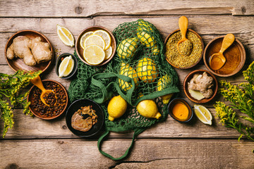 Ingredients for healthy hot drink. Lemon, ginger, honey, and turmeric in a bowls on a wooden background. Ambrosia, pollen and propolis in a bowls. Alternative medicine concept. Clean eating, detox.