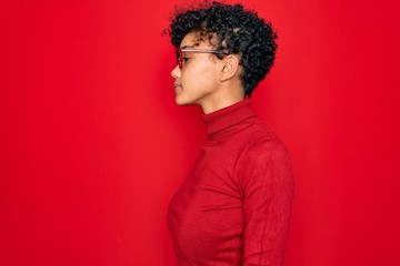 Young beautiful african american afro woman wearing turtleneck sweater and glasses looking to side, relax profile pose with natural face and confident smile.