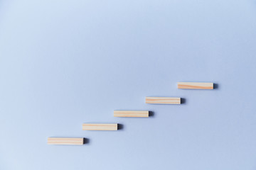 Increase and decrease. Growth and fall concept. Copy space. Wooden blocks in growing and lowering order on blue